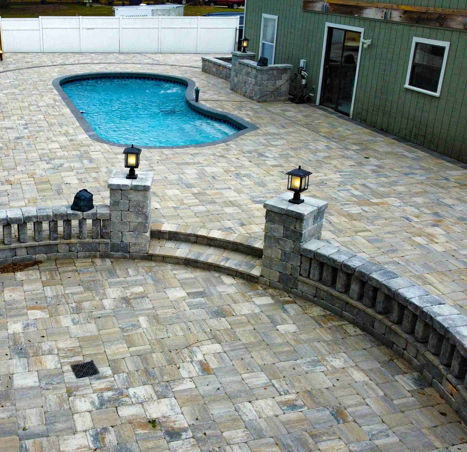 Pool deck with retaining wall columns and landscape lighting