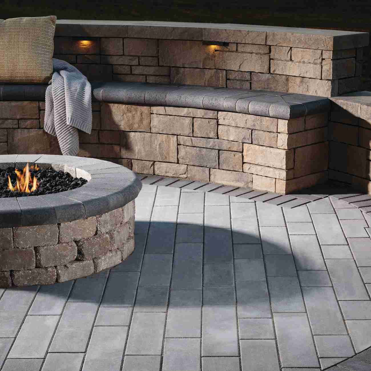 Fire pit with seating wall and built-in lighting at night